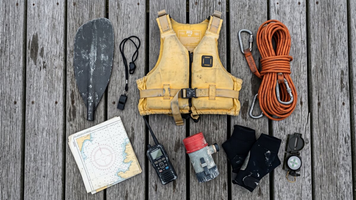 Typical sea kayaking gear laid out on a pier before launch